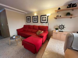 阿里纳加Las Nasas, Acogedor apartamento cerca de la playa的客厅配有红色的沙发和桌子