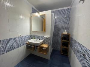 阿里纳加Las Nasas, Acogedor apartamento cerca de la playa的蓝色和白色的浴室设有水槽和镜子