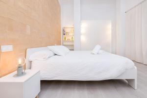 孔佩塔Homey apt Cómpeta的白色的卧室设有白色的床和窗户。