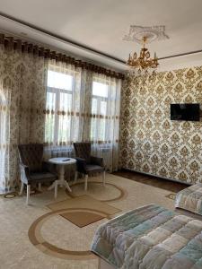 KogonTURKISTAN Hotel的卧室配有一张床和一张桌子及椅子
