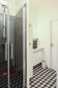 图卢兹Confortable T2 à Saint Aubin的带淋浴的浴室以及黑白格子地板。