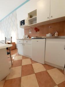 凯希道库什塔尼佩特拉公寓的厨房配有白色橱柜和瓷砖地板。