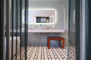 哥本哈根亚历山德拉酒店的一间带水槽、桌子和镜子的浴室
