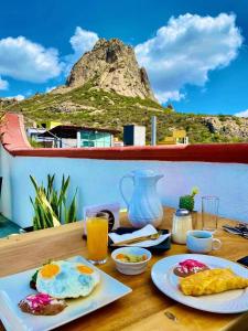 克雷塔罗Hotel Hacienda Real的一张带早餐食品的桌子,背景是一座山。
