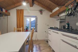 阿莱盖Una Civetta sul Lago的厨房配有白色的柜台和窗户。