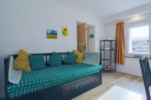 阿莱盖Una Civetta sul Lago的客厅配有带黄色枕头的绿色沙发