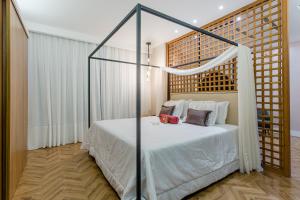 尤西德福拉胜利商务酒店 的一间卧室配有一张带天蓬的白色床