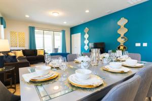 基西米Blue Stylish Charming Villa with Pool near Disney的用餐室配有带盘子和玻璃杯的桌子
