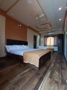 卡尔贾特Kalwars Millennials Park的一间铺有木地板并配有一张大床的大卧室