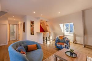 翁弗勒尔Soft time - Luxury flat - Historic Centre Honfleur的客厅配有2把蓝色椅子和桌子