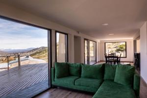 埃斯克尔El Mirador的客厅设有绿色沙发和阳台。