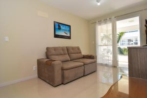 弗洛里亚诺波利斯Apto Vista Mar, 10 min da praia no Campeche P1331的客厅里设有一张棕色沙发,配有窗户