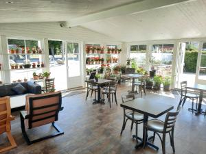 Borrby霍比农场酒店的用餐室设有桌椅和窗户。
