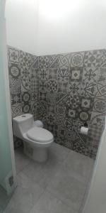 圣玛丽戴尔奥罗Hotel Lucero Chan的一间带卫生间和瓷砖墙的浴室