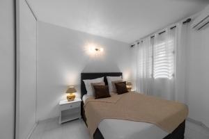 莱特鲁瓦西莱Eirene - Trois Ilets的白色的卧室设有床和窗户