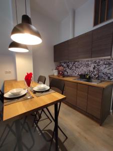 马德里Precioso apartamento en Puente Vallecas, Madrid.的厨房配有木桌、椅子和水槽