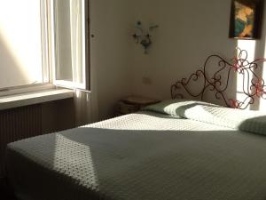 格拉多Villa Giulia的卧室配有一张带白色棉被的床和窗户。
