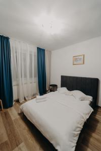 瓦特拉多尔内Apartamentul Albastru的一张白色的大床,房间配有蓝色窗帘