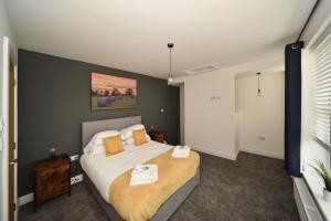 麦克尔斯菲尔德Pinfold Suite - Chester Road Apartments By的一间卧室配有一张大床和两条毛巾