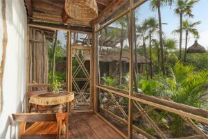 图卢姆Yaxchen Tulum Cabañas & Cenote的配有桌椅和树木的客房