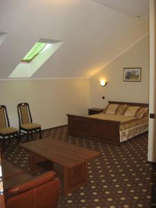伊尔平沙图天堂酒店的卧室配有一张床和一张桌子及椅子