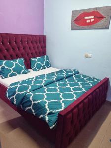 杜阿拉Residence Sighaka - Studio Meublé VIP avec WiFi, Gardien, Parking的一张带红色床头板和蓝色床单及枕头的床