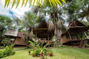 NautaPacaya Samiria Amazon Lodge - ALL INCLUSIVE的一座棕榈树度假村,位于一座建筑前