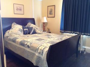 Saint-André-Avellin吉尔安住宿加早餐旅馆的卧室内的一张床铺,配有蓝色窗帘