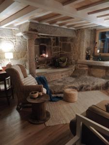 San Mamede de CarnotaOLardoMar的客厅设有石制壁炉和桌子。
