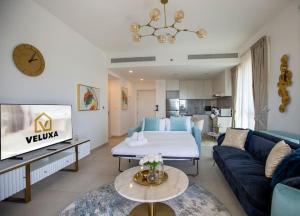 迪拜Veluxa - Luxury and bright 1 bedroom apartment, Burj view!的客厅配有蓝色的沙发和床。