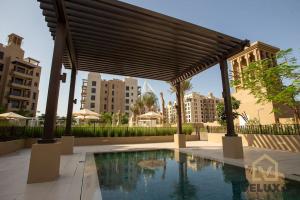 迪拜Veluxa - Luxury and bright 1 bedroom apartment, Burj view!的城市中带游泳池的凉亭