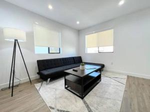 洛杉矶4BR Townhouse in KoreaTown的客厅配有黑色沙发和桌子