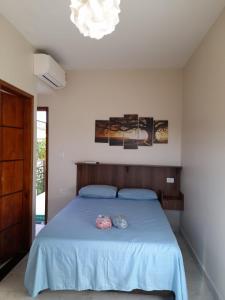 瓜鲁雅Pousada Reis Guarujá的一间卧室配有一张带蓝色床单和吊灯的床。