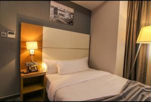 阿尔及尔El Ghanami Hotel的酒店客房配有一张床、一张桌子和一部电话