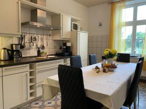 KluisChalet Heiderose SPA - Kamin, Sauna & Wellness的厨房配有桌椅和桌子。