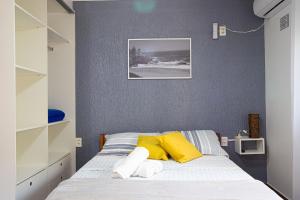 加罗帕巴Residencial Paraíso da Gamboa的一间卧室配有黄色和白色枕头的床