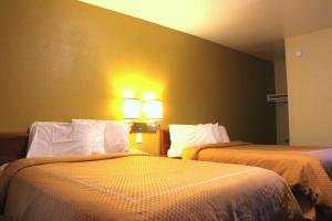 西萨克拉门托回声汽车旅馆的一间设有两张床的房间和墙上的两盏灯