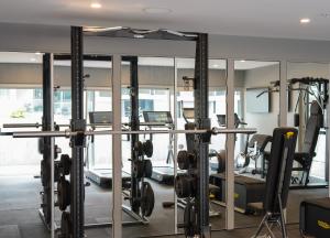 悉尼The Porter House Hotel Sydney - MGallery的健身房设有数台跑步机和镜子