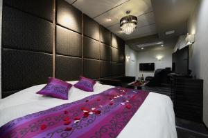 BandoHotel S-CUBE (Adult Only)的一间卧室配有一张带紫色枕头的大床