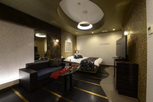 BandoHotel S-CUBE (Adult Only)的酒店客房,配有床和沙发