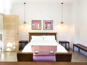 北碧切兹布尔民宿的一间卧室配有一张带长凳的床和两张桌子