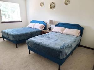 埃弗里特Spacious and peaceful 4 bedroom home的一张桌子的房间里设有两张蓝色的床