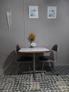 危地马拉Nirvana Hermosa habitación individual e independiente的一张桌子,上面有两把椅子和一个花瓶