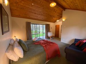 ApitiMakoura Lodge的一间卧室配有一张床、一张沙发和一个窗口