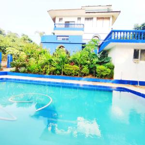 果阿旧城Hilltop 4BHK Villa with Private Pool Near Candolim的房屋前的游泳池