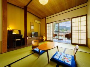 嬉野市Ureshino Onsen Kotobukiya的一间带桌椅的房间和一间客厅