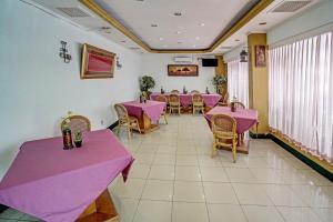巨港SUPER OYO 91805 Hotel Wisma Bari的用餐室配有粉红色的桌椅