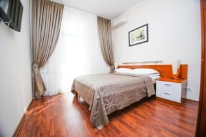 阿特劳阿迪吉尔住宅酒店的一间卧室配有一张床,铺有木地板