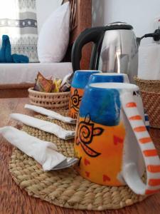 帕杰Amani Hotel Paje的一张桌子,配有两个咖啡杯和茶壶