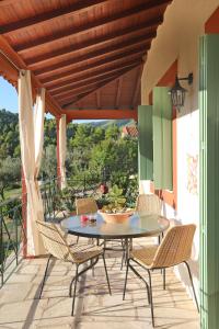 帕诺尔莫斯斯科派洛斯Blue & Green Villa的阳台的天井配有桌椅